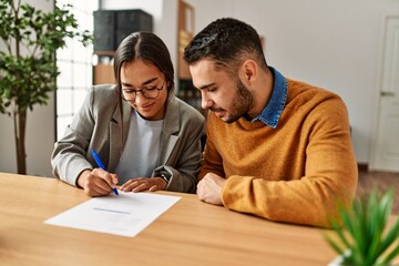 couple signing postnuptial agreement