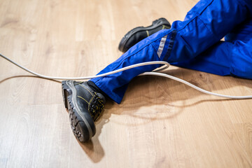 person's legs on the ground after tripping over cable