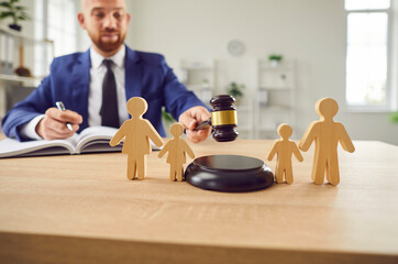 man with gavel and wooden family people