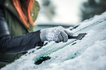 woman scraping snow from car