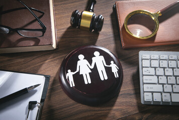 gavel on desk with paper cutout of family silhouettes including 2 parents and 2 children; Bergen County Family Lawyers concept image