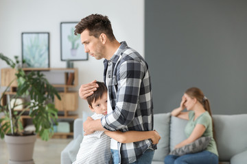 child hugging dad while mom is on couch