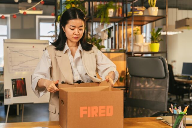 woman with box that says fired